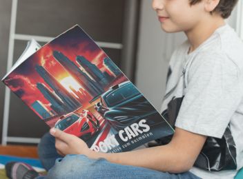 Vorschulkind liest Malbuch mit Sportautos – ideal für Jungs mit Auto-Fieber
