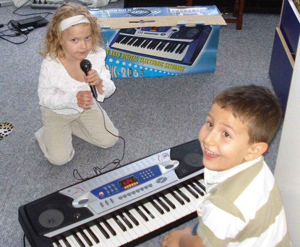 Kinder spielen Musik mit Keyboard.