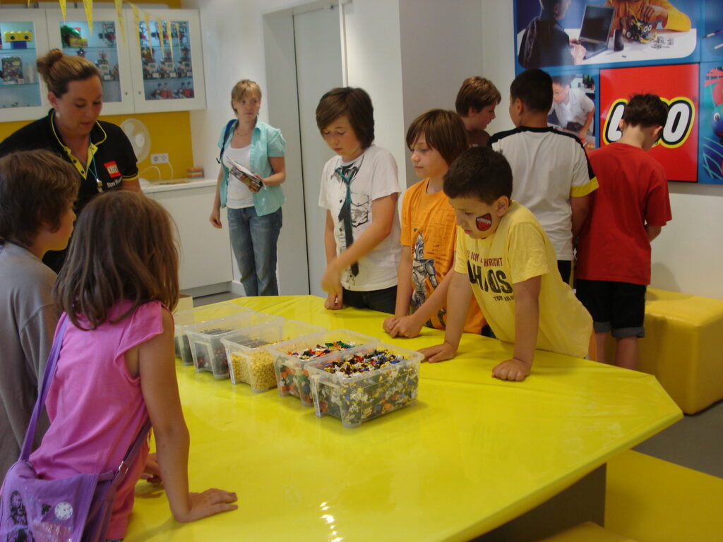 6 Kinder spielen mit LEGO-Steinen.