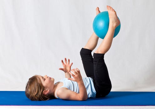 pexels-photo-3992594-3992594 Young girl practicing balance exercises with a blue yoga ball indoors on a mat.